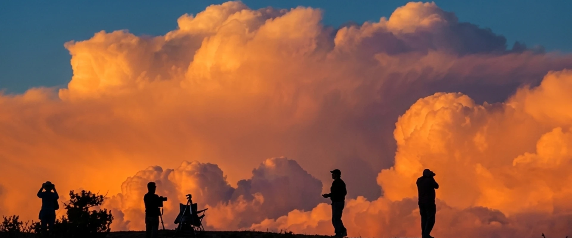 Silhouettes of people against dramatic sunset clouds.